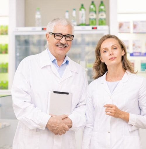 pretty-blond-female-pharmacist-and-her-senior-colleague-in-whitecoats-1024x682